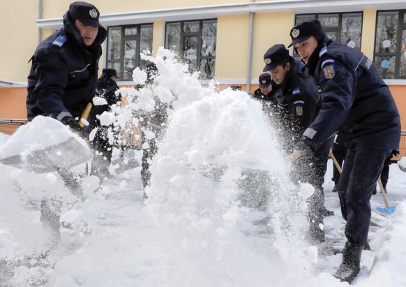 Romanian gendarmes clear the snow outside a school, as temperatures dropped below minus 20 degrees Centigrade ( minus 4 Fahrenheit) in Bucharest, Romania, Tuesday, Jan. 10, 2017. Romania&#039;s Energy ...