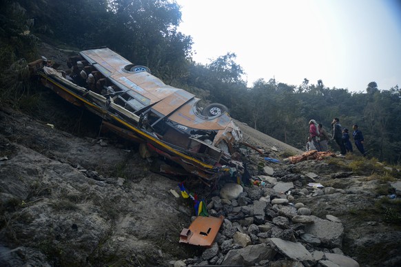 epaselect epa12771012 People gather at the site of a passenger bus crash in Benighat, Dhading District, Nepal, 23 February 2026. At least 18 people were killed and 24 were injured in the accident, aut ...