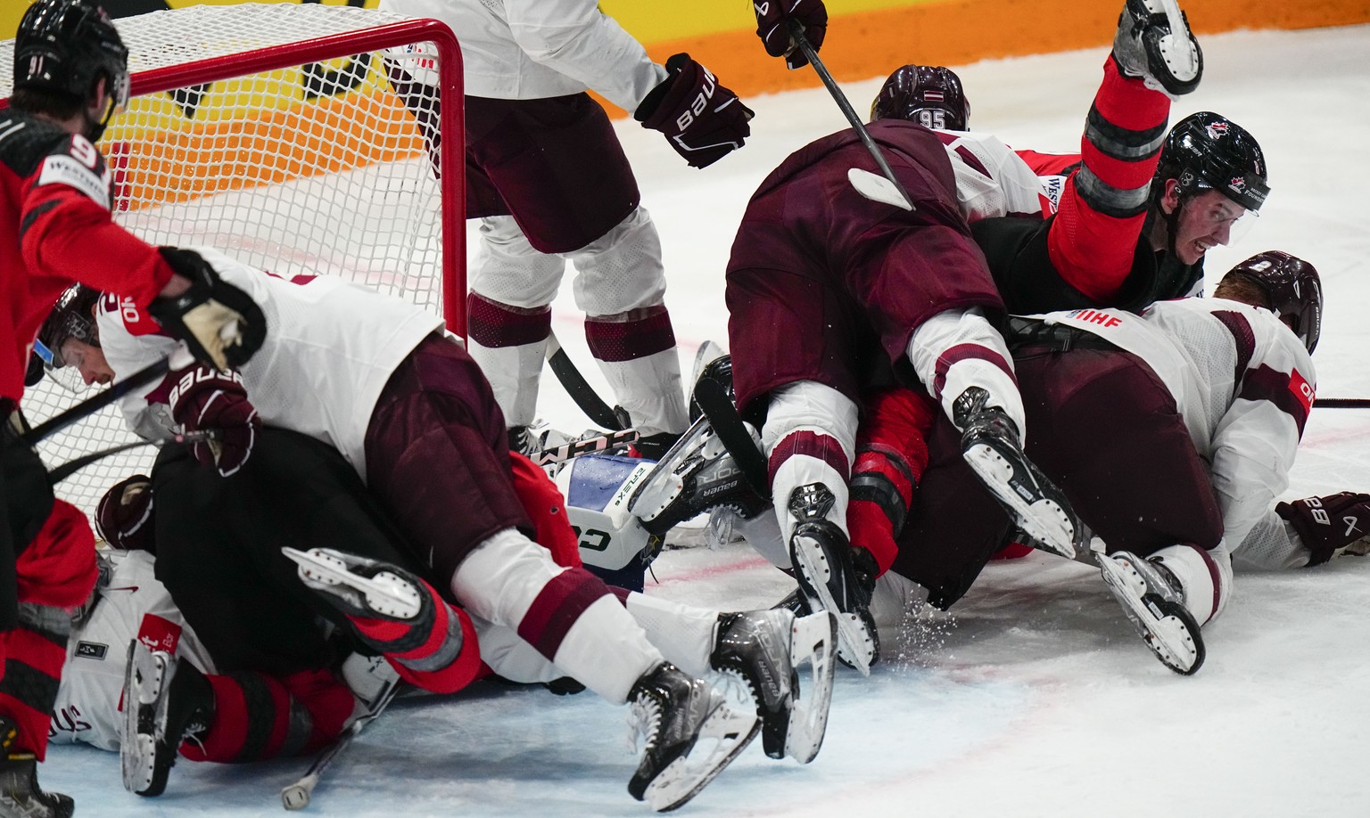 Canada and Latvia (white) battle at the net during their semifinal match at the Ice Hockey World Championship in Tampere, Finland, Saturday, May 27, 2023. (AP Photo/Pavel Golovkin)