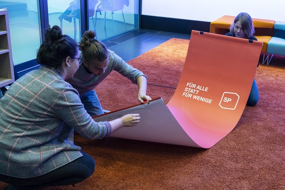 Personen entrollen einen SP-Banner an einer ueberparteilichen Medienkonferenz zur Vorlage �Steuerliche Beruecksichtigung der Kinderdrittbetreuungskosten�, am Montag,15. Juni 2020, in Bern. (KEYSTONE/P ...