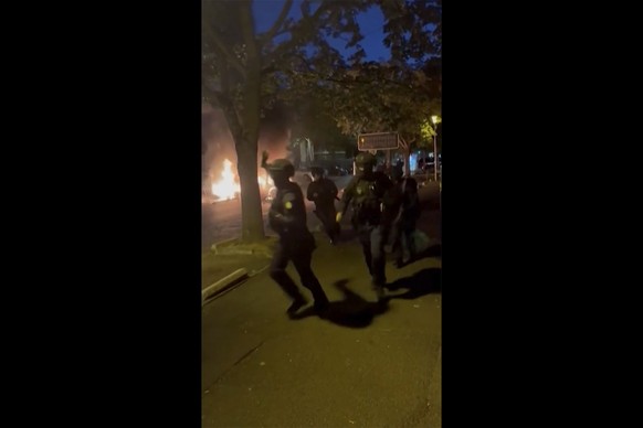 In this image made from video provided, police officers try to control people on a street in Nanterre, France Tuesday, June 27, 2023. A 17-year-old delivery driver was shot and killed by a police offi ...