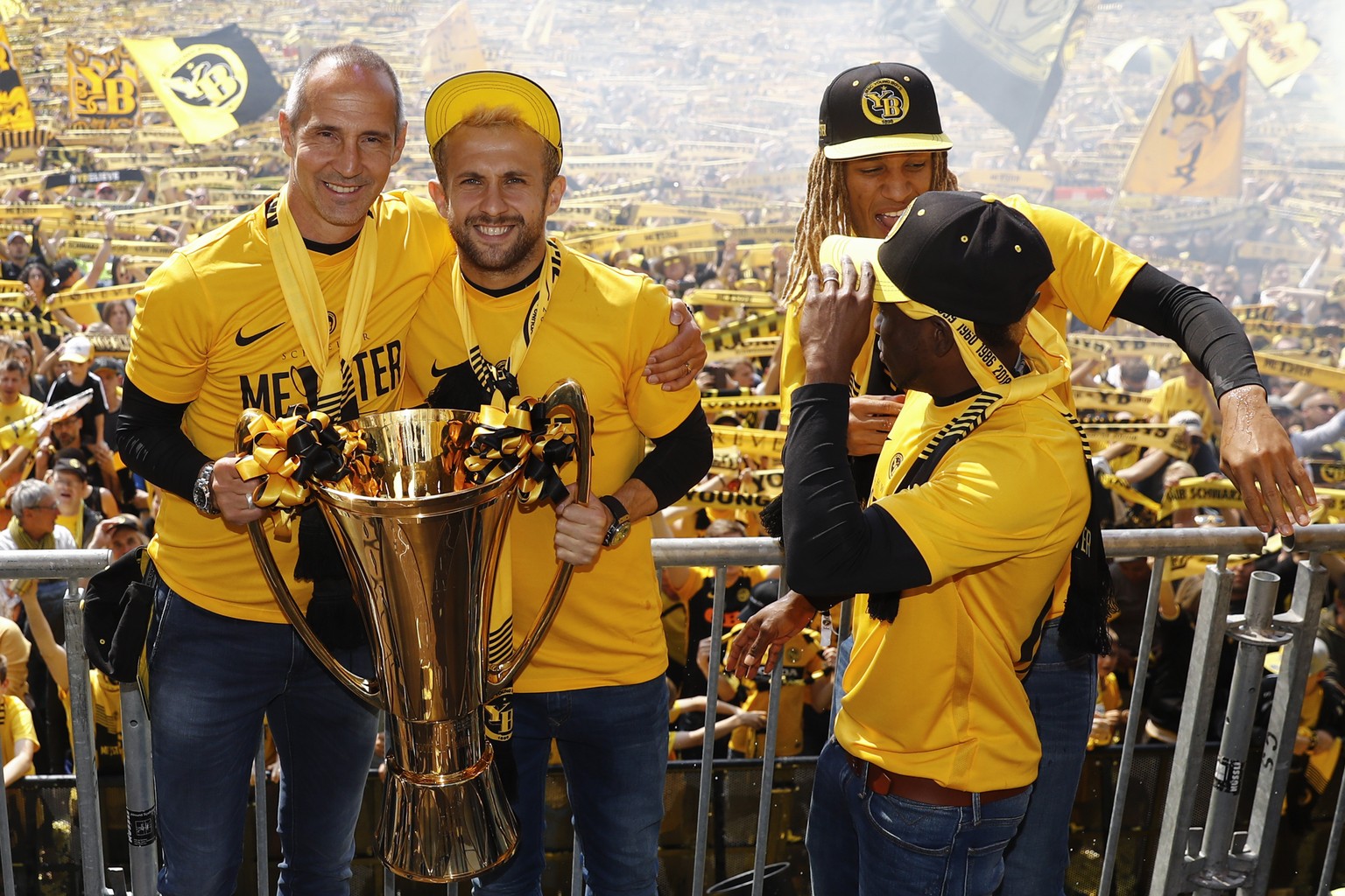 Berns Trainer Adi Huetter, links, und Berns Miralem Sulejmani posieren mit dem Pokal neben Kevin Mbabu und Roger Assale, bei der Meisterfeier der Berner Young Boys, am Sonntag, 20. Mai 2018 auf dem Bu ...