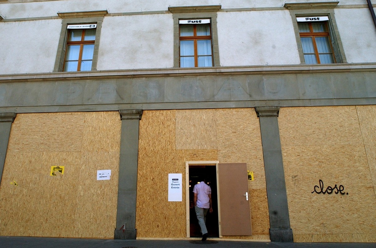 A man enters a boarded up storefronts in Geneva, Switzerland, Friday, May 30, 2003. The G8 summit will take place in Evian, France from June 1 to June 3 and brings together leaders of France, the Unit ...