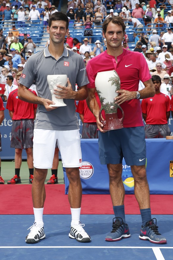 Roger Federer, right, of Switzerland, and Novak Djokovic, of Serbia, hold their trophies after the men&#039;s final at the Western &amp; Southern Open tennis tournament, Sunday, Aug. 23, 2015, in Maso ...