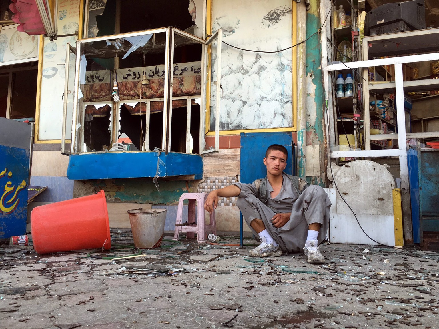 epaselect epa05437879 A boy, in a state of shock, sits near the scene of a suicide bomb attack that targeted a demonstration of Hazara minority in Kabul, Afghanistan, 23 July 2016. According to report ...