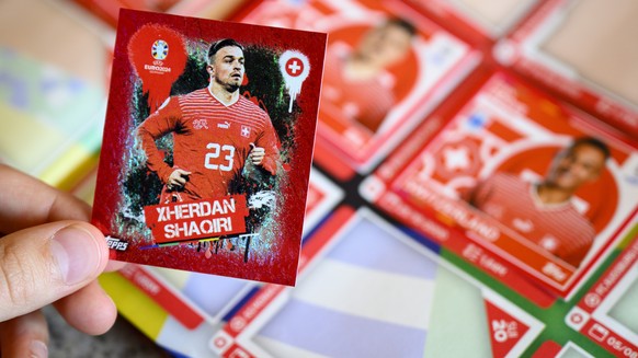 A young collector sticks a Topps Euro 2024 sticker of the Switzerland&#039;s soccer national team (Xherdan Shaqiri) in the official Topps album of the UEFA Euro 2024 Germany, in Lausanne, Friday, Apri ...