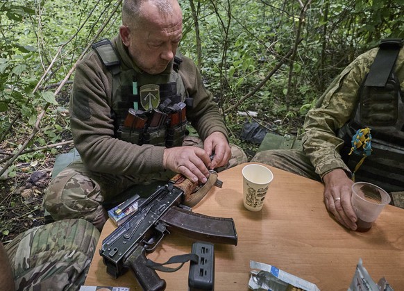 epa12195192 Ukrainian servicemen of the 57th Separate Motorized Brigade named Otaman Kost Hordiienko resting near their position at an undisclosed location on the frontline in the Kharkiv area, Ukrain ...
