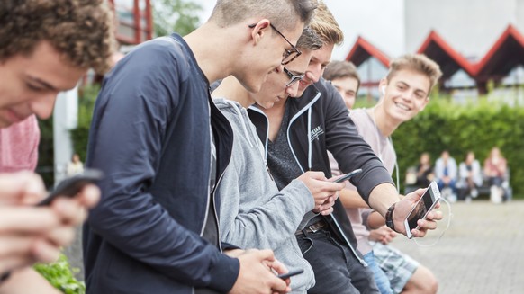 ARCHIVBILD ZUM ENTSCHEID DES BUNDESRATES GEGEN ZU HOHE ROAMING-TARIFE VORGEHEN ZU WOLLEN, AM DONNERSTAG, 7. SEPTEMBER 2017 - A group high school students use their smart phones on the schoolyard of th ...