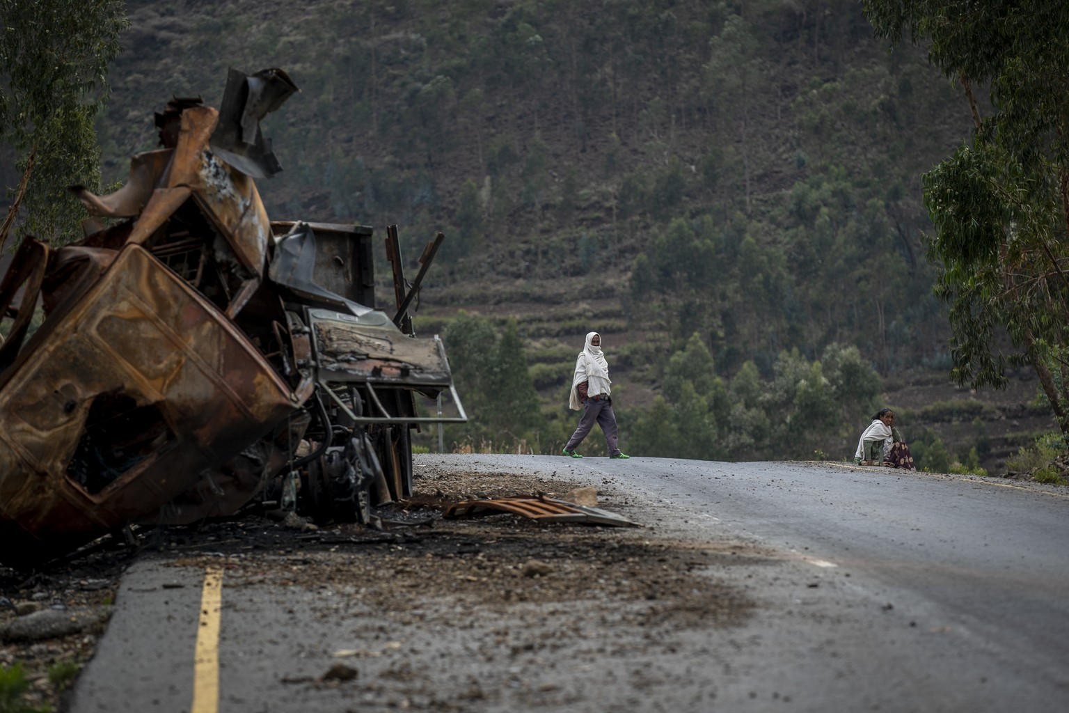 FILE - A man crosses near a destroyed truck on a road leading to the town of Abi Adi, in the Tigray region of northern Ethiopia on May 11, 2021. A spokesman for Tigrayan authorities said Tuesday, Sept ...