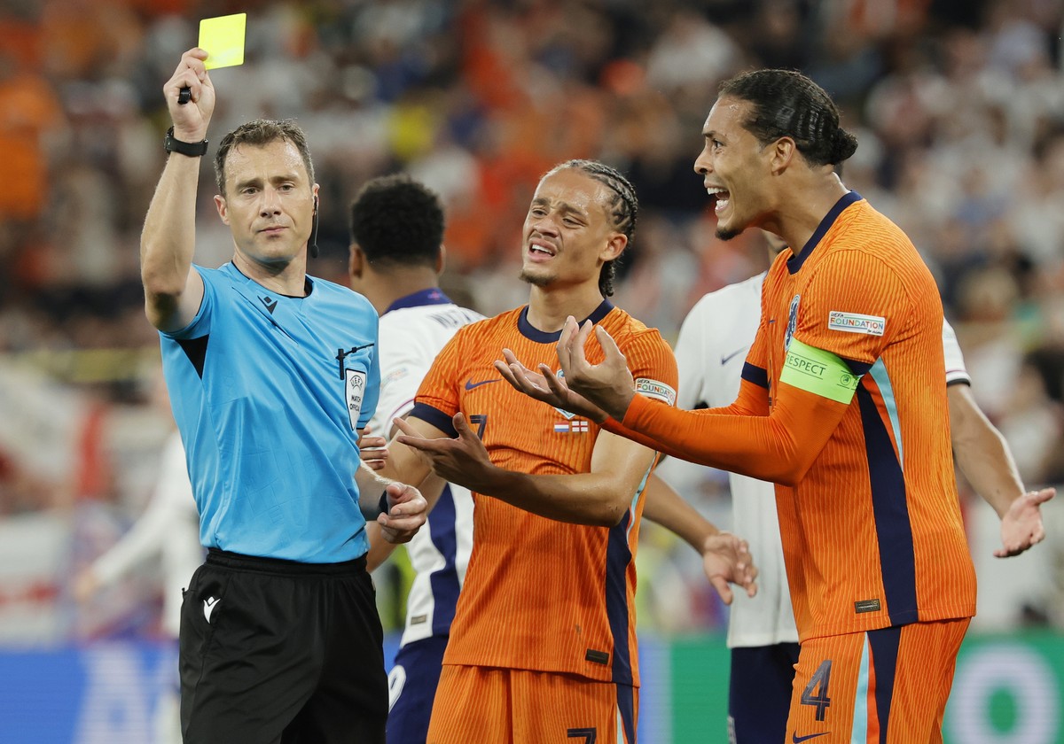 epa11471376 Referee Felix Zwayer (L) shows a yellow card to Virgil van Dijk of Netherlands (R) the UEFA EURO 2024 semi-finals soccer match between Netherlands and England, in Dortmund, Germany, 10 Jul ...
