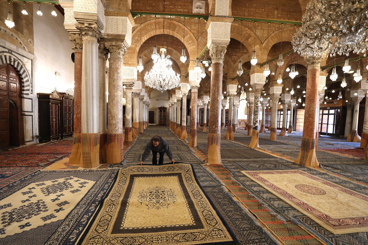 epa11928003 A worker arranges a prayer carpet at the Al-Zaytuna Mosque, amid preparations for the Muslim holy month Ramadan, in Tunis, Tunisia, 27 February 2025. The first day of Ramadan, the ninth mo ...