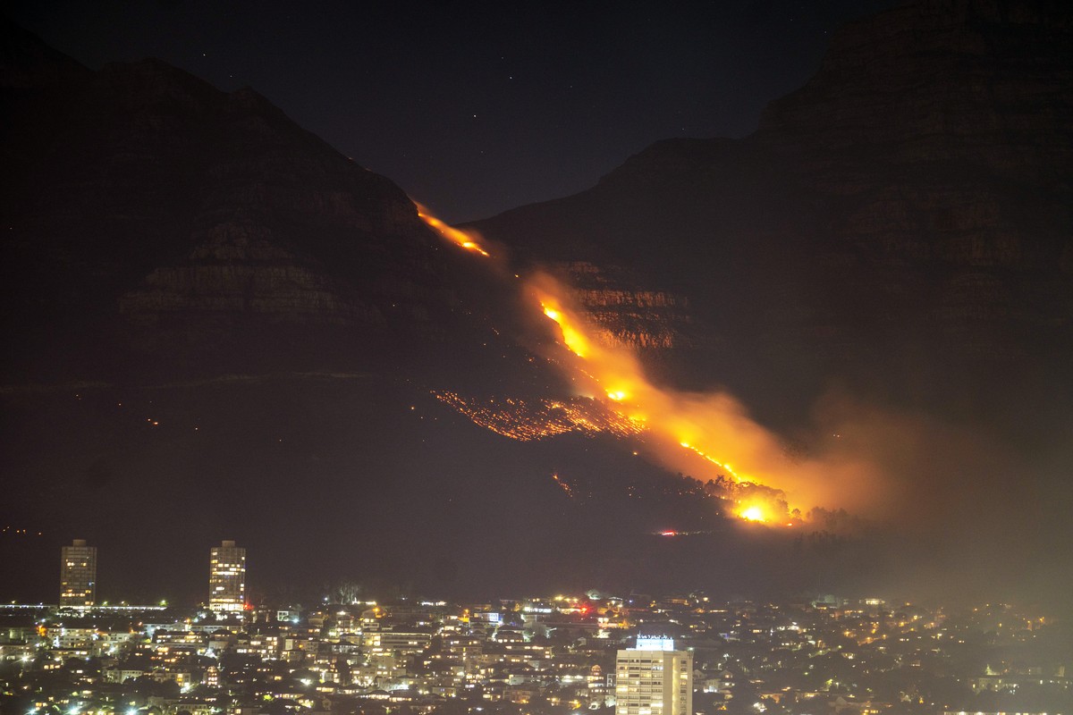 Residential neighborhoods are lit by raging fires in Cape Town, South Africa, Monday, April 19, 2021. Residents are being evacuated from Cape Town neighborhoods after a huge fire spreading on the slop ...