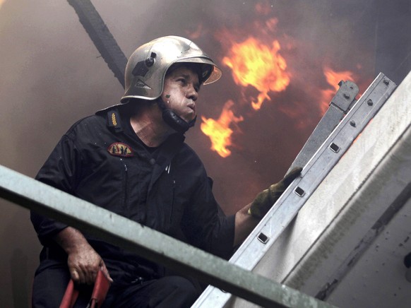 epa04850414 A fireman tries to extinguish a fire in Karea, suburb of Athens, Greece, 17 July 2015. Due to the strong winds blowing in the area the blaze is now very close to the inhabited area. EPA/OR ...