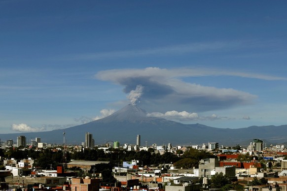epa07984536 General view that shows an explosion of the Popocatepetl Volcano, seen from the city of Puebla, Mexico, 09 November 2019. The monitoring systems of the Popocatepetl volcano identified 64 e ...