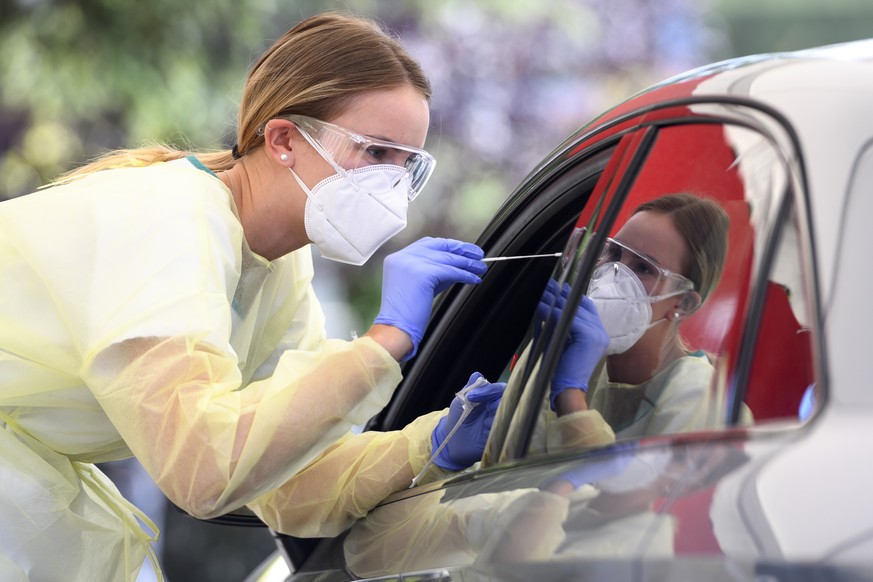 A health worker collects a nose swab sample for a polymerase chain reaction (PCR) test at a drive-in coronavirus testing facility in front of the eHnv hospital eHnv &quot;Etablissements Hospitaliers d ...