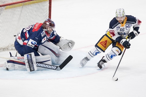 ZSC Goalie Lukas Flueeler, links, spielt um den Puck gegen Zugs Lino Martschini, rechts, im vierten Eishockey Playoff-Viertelfinalspiel der National League zwischen den ZSC Lions und dem EV Zug, am Sa ...