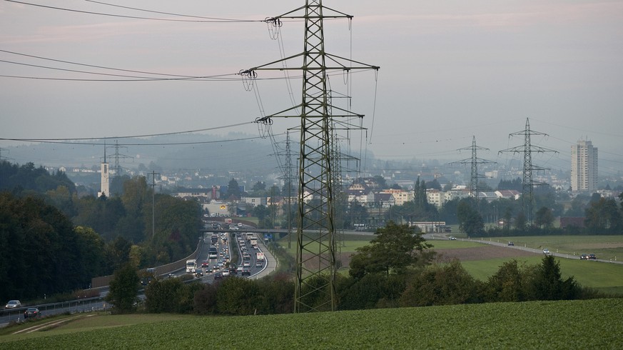 ARCHIV --- ZUR DISKUTIERTEN STROMMARKTOEFFNUNG STELLEN WIR IHNEN FOLGENDES BILD ZUR VERFUEGUNG --- Hochspannungsmasten saeumen die Autobahn A1, aufgenommen am 5. Oktober 2009 in Walterswil im Kanton S ...