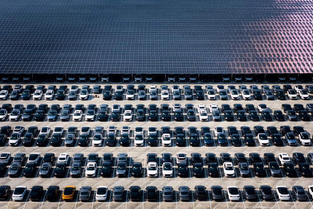 FILE - New cars wait for shipment in a parking lot partially covered by solar panels at the distribution center of Changan Auto, in southwest China's Chongqing Municipality on July 6, 2025. (Chin ...