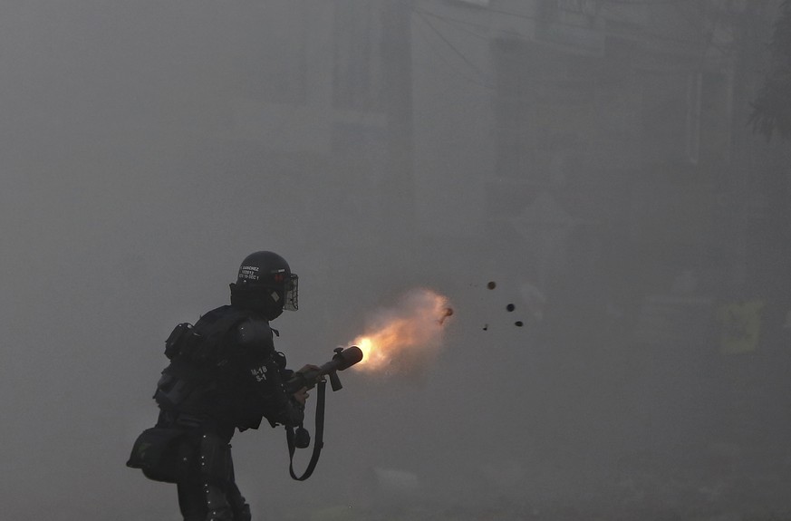A police officer fires tear gas at protesters during a strike against tax reform in Cali, Colombia, Monday, May 3, 2021. Colombia&#039;s President Ivan Duque withdrew the government-proposed tax refor ...