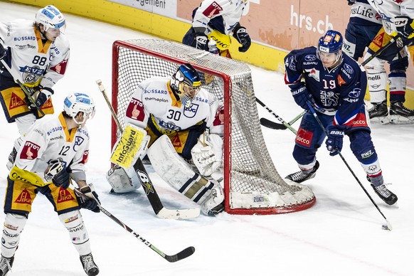 Zugs Sven Senteler, Zugs Yannick Zehnder, Zugs Torhueter Leonardo Genoni und Zuerichs Reto Schaeppi, von links, beim Eishockey Meisterschaftsspiel der National League zwischen den ZSC Lions und dem EV ...