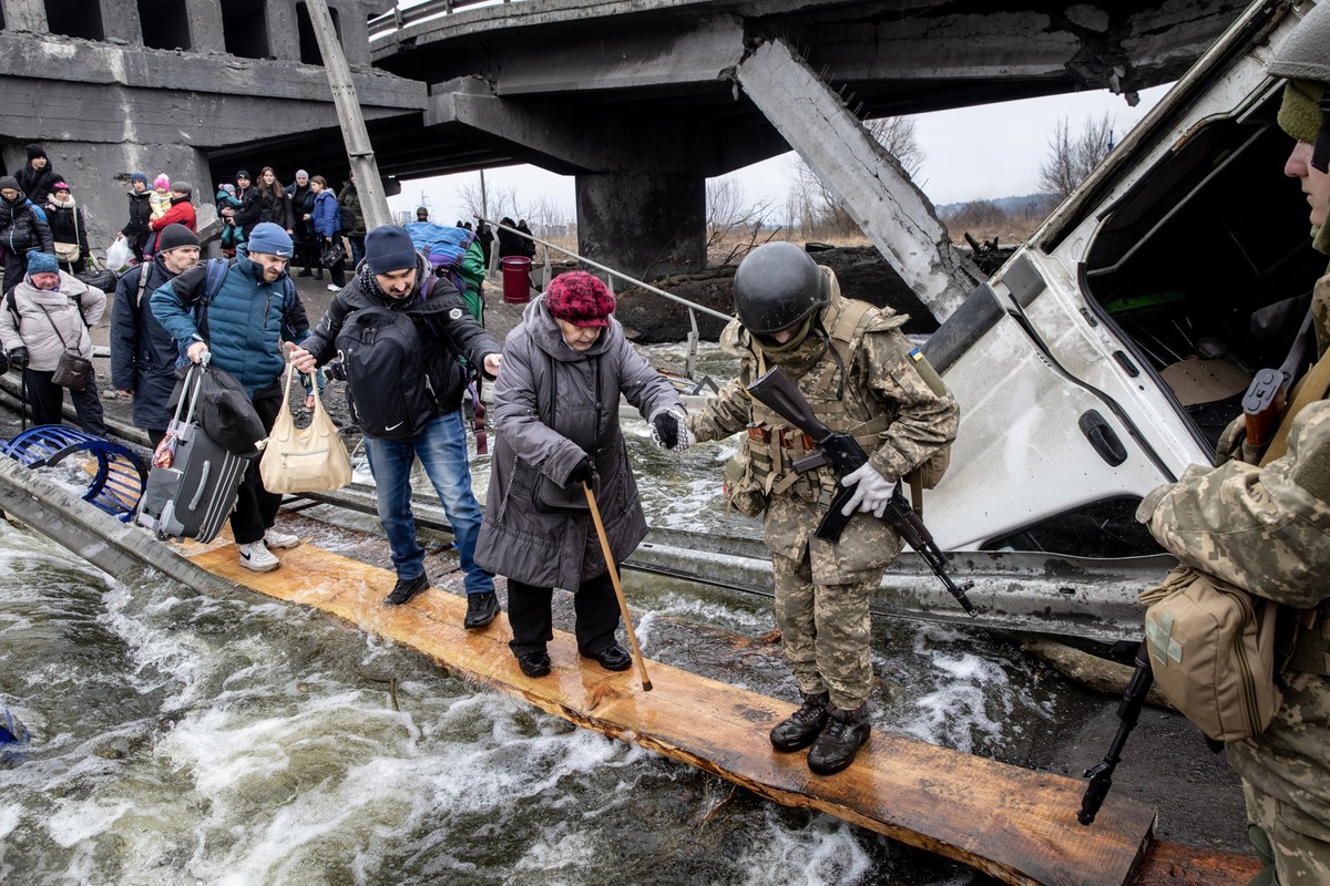 IRPIN, UKRAINE - MARCH 07: Residents of Irpin flee heavy fighting via a destroyed bridge as Russian forces entered the city on March 07, 2022 in Irpin, Ukraine. Yesterday, four civilians were killed b ...