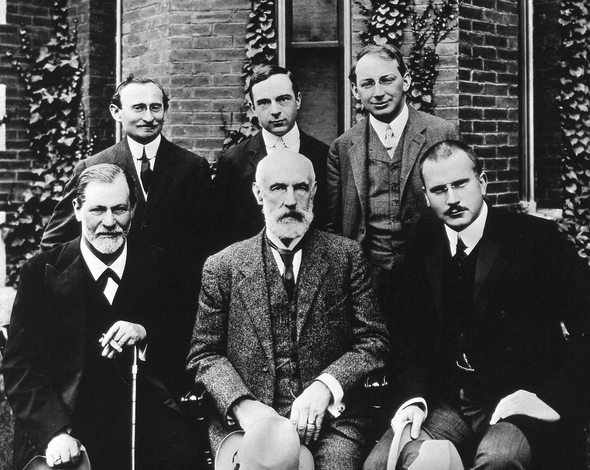 1909 wurde Freud (links unten) die Ehrendoktorwürde an der Clark University, Massachusetts, verliehen. Jung (rechts unten) reiste mit ihm. Zwischen den beiden sitzt G. Stanley Hall, in der hinteren Re ...