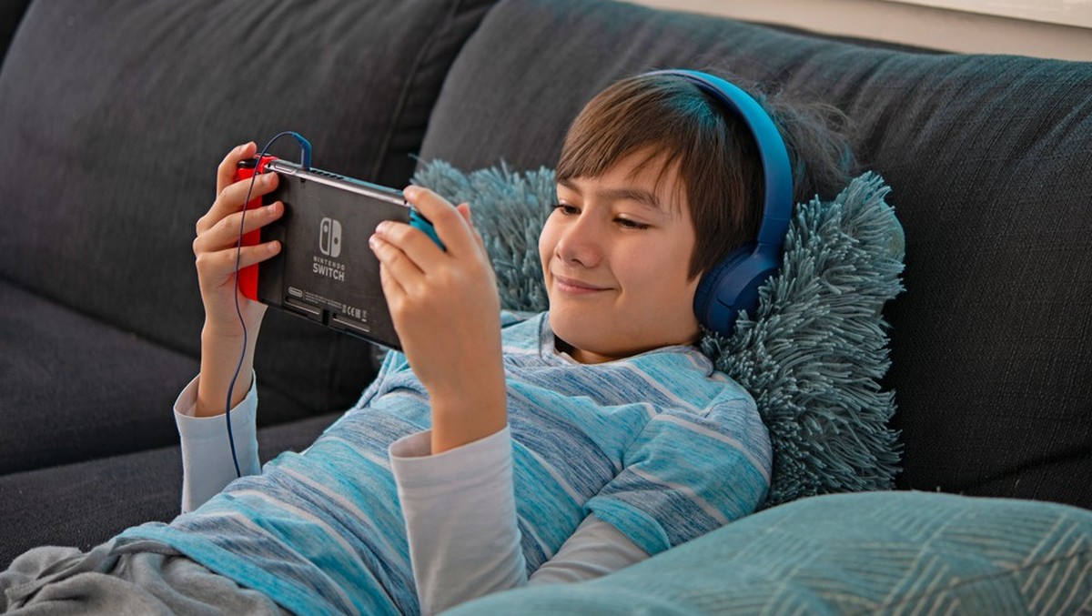 Gemütlich auf dem Sofa liegen und eine Runde Nintendo Switch spielen.