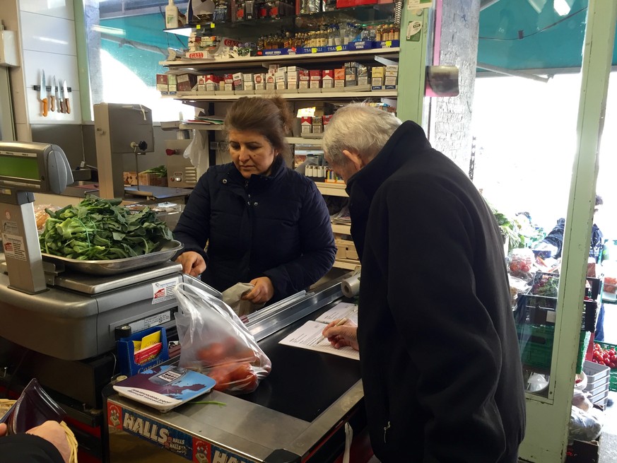 Fatma Yapici an der Kasse. Ein Kunde unterschreibt die Petition für den Dirok Market.