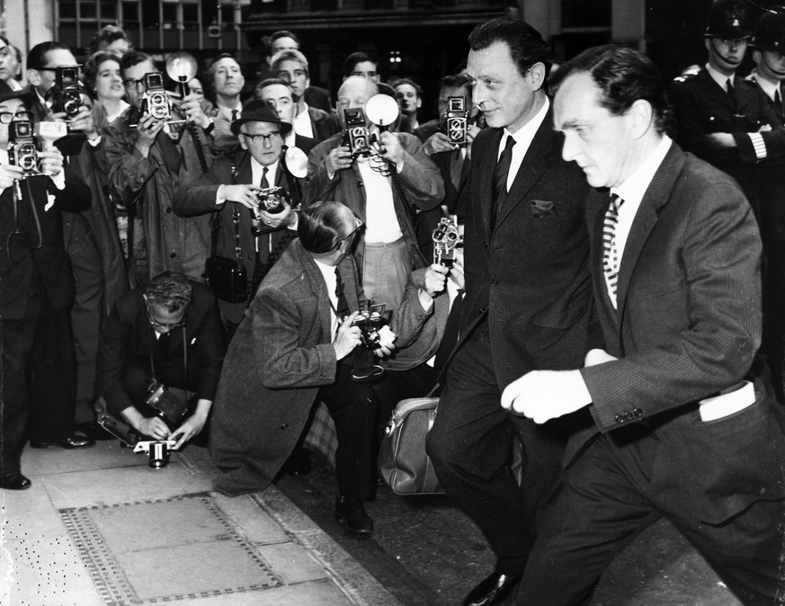 Stephen Ward, Londoner Osteopath, Mitte, und in den Fall Profumo verwickelt, schreitet am 24. Juli 1963 zum Gerichtstermin in London, vorbei an Schaulustigen und Fotografen. Die Profumo-Affaere war ei ...