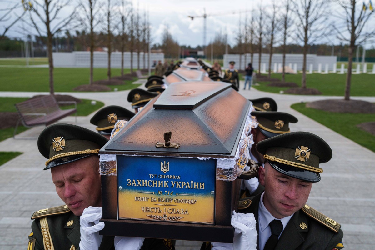 FILE - An honor guard carries the coffins of unidentified Ukrainian soldiers killed in battle during the Russian-Ukrainian war at a funeral ceremony at a military cemetery near Kyiv, Ukraine, April 30 ...