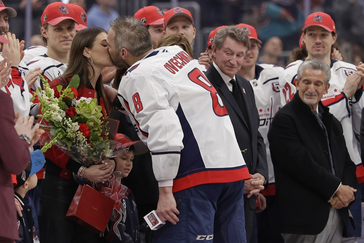 Washington Capitals left wing Alex Ovechkin (8) kisses his wife Nastya during a ceremony after he scored his 895th career goal during the second period of an NHL hockey game against New York Islanders ...