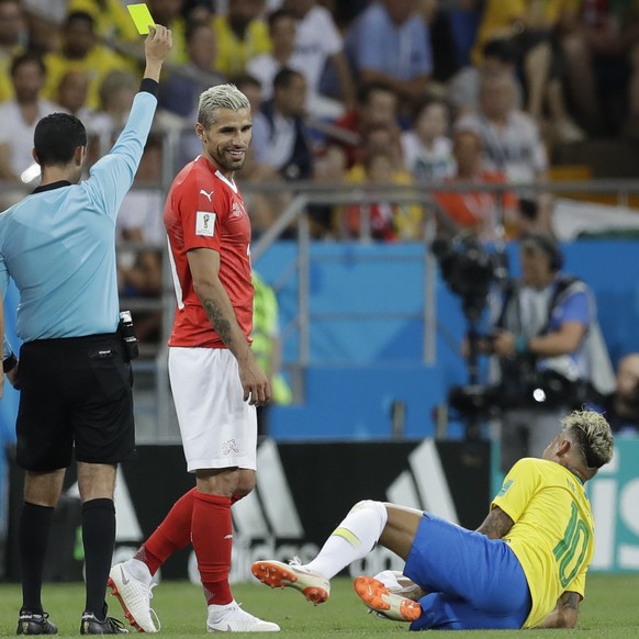 Referee Cesar Arturo Ramos shows a yellow card to Switzerland&#039;s Valon Behrami, centre, during the group E match between Brazil and Switzerland at the 2018 soccer World Cup in the Rostov Arena in  ...