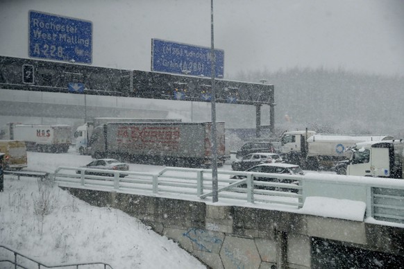 Vehicles crawl along a road as snow falls in south east England, as seen through the window of a train travelling from London to Canterbury, England, Tuesday, Feb. 27, 2018. The so-called "Beast from the East" snow storm arrived in the Britain Monday and is predicted to continue for the next few days as it chills most of Europe. (AP Photo/Matt Dunham)