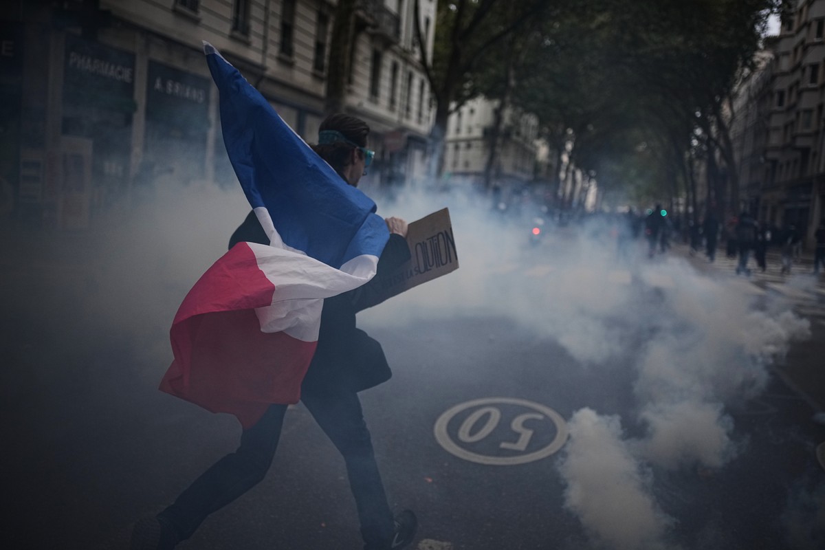 KEYPIX - A protester holds a French flag during a demonstration against rising living costs in Lyon, France, Saturday, Oct. 24, 2026. (KEYSTONE/AP Photo/Laurent Cipriani)