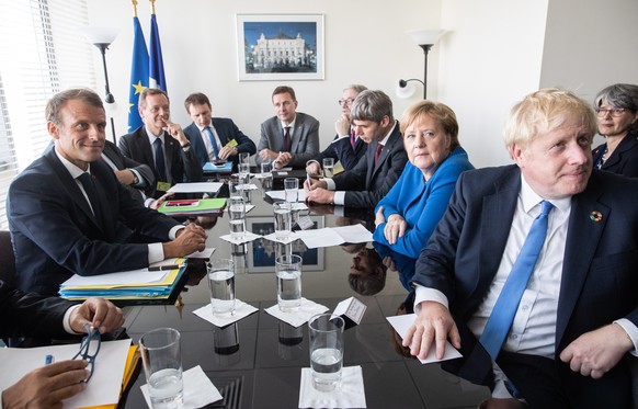 epa07864710 President of France Emmanuel Macron (L), German Chancellor Angela Merkel (2R), and British Prime Minister Boris Johnson (R) meet after the United Nations (UN) Climate Action Summit 2019 at ...