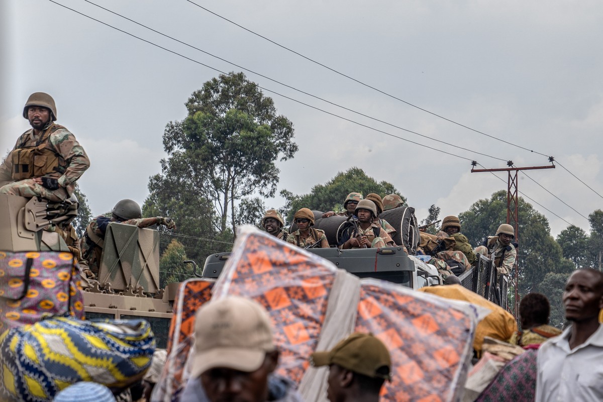 epa11134165 Soldiers from the Southern African Development Community (SADC) Mission in the Democratic Republic of Congo drive past locals fleeing a resumption of fightings, East of Goma, North Kivu, D ...