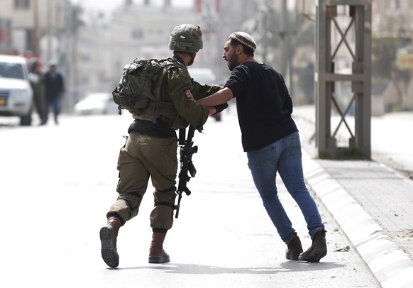 epaselect epa10493602 Israeli settlers and soldiers at the scene of a shooting attack in the West Bank town of Hawera after a shooting attack the day before in which two Israelis were killed, near the ...