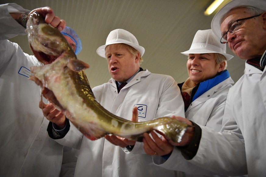 FILE - In this Dec. 9, 2020 file photo, Britain&#039;s Prime Minister and Conservative Party leader Boris Johnson, center, visits Grimsby fish market in Grimsby, northeast England. On the eve of a Eur ...