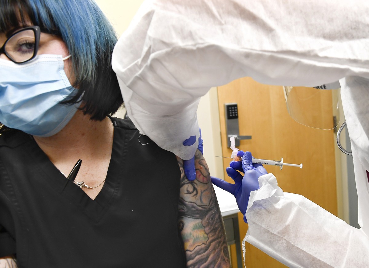Nurse Kathe Olmstead, right, gives volunteer Melissa Harting, of Harpersville, N.Y., an injection as the world's biggest study of a possible COVID-19 vaccine, developed by the National Institutes ...