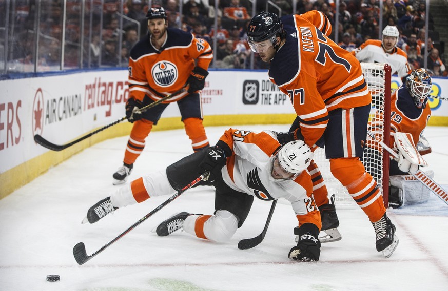Philadelphia Flyers' Scott Laughton (21) is tripped by Edmonton Oilers' Oscar Klefbom (77) during the first period of an NHL hockey game Wednesday, Oct. 16, 2019, in Edmonton, Alberta. (Jason Franson/ ...
