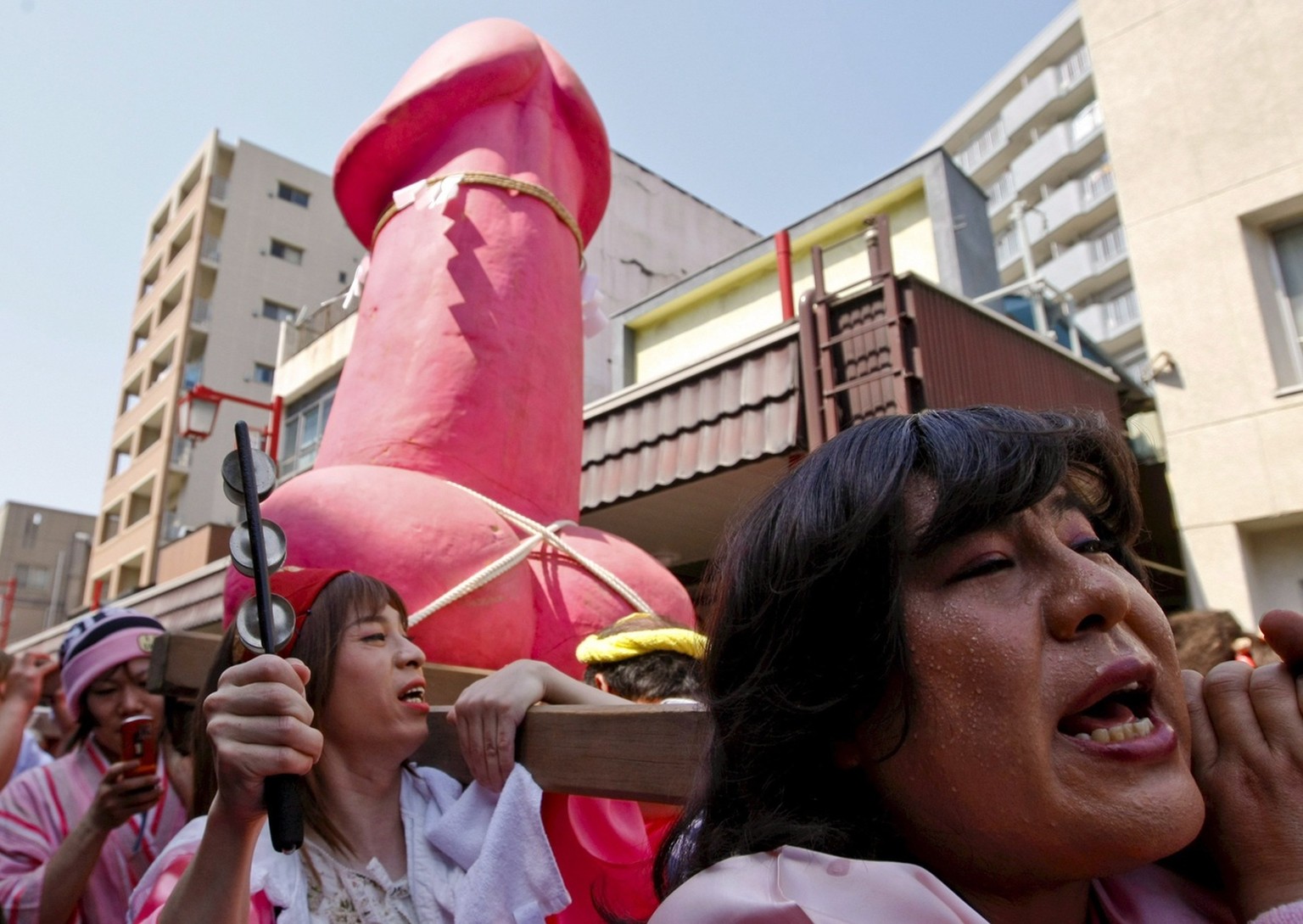 epa01306271 A large phallus-like portable shrine named 'Elizabeth Mikoshi (portable shrine)' is carried by a group of Japanese transvestites after being consecrated by a Shinto priest during ...