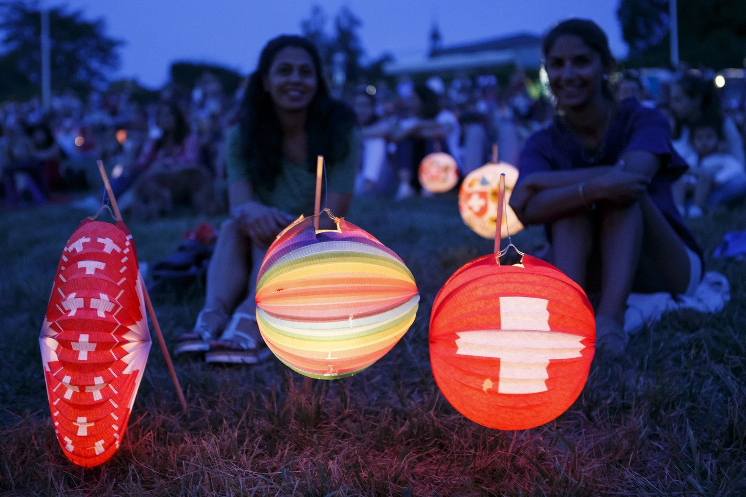 Spectators past lanterns with the Swiss colors listen a speech, during the Swiss National Day, in Cologny near Geneva, Switzerland, Tuesday, August 1, 2017. (KEYSTONE/Salvatore Di Nolfi)