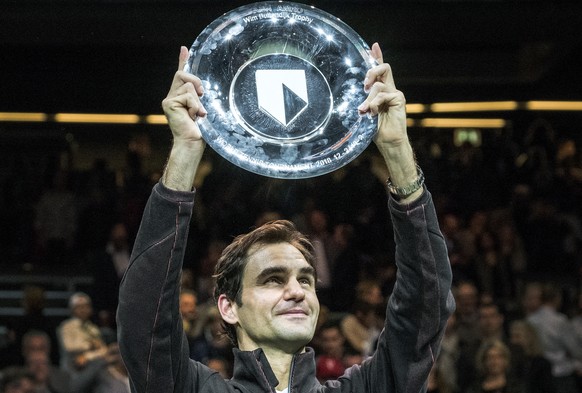 Roger Federer of Switzerland holds up the trophy as he celebrates winning his match against Bulgaria&#039;s Grigor Dimitrov in two sets, 6-2, 6-2, in the men&#039;s singles final of the ABN AMRO world ...