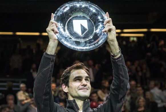 Roger Federer of Switzerland holds up the trophy as he celebrates winning his match against Bulgaria's Grigor Dimitrov in two sets, 6-2, 6-2, in the men's singles final of the ABN AMRO world ...