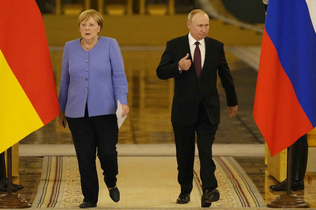 epa09422165 German Chancellor Angela Merkel (L) and Russian President Vladimir Putin (R) arrive for a joint news conference following their talks in the Kremlin in Moscow, Russia, 20 August 2021. Germ ...
