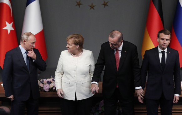 epa07124883 Russian President Vladimir Putin (L), German Chancellor Angela Merkel (2-L), Turkish President Recep Tayyip Erdogan (2-R) and French President Emmanuel Macron (R), react after their press  ...