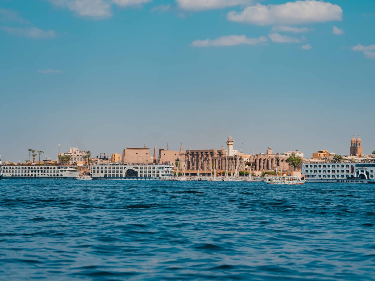 Blick über den Nil auf die moderne Stadt Luxor und den Luxor Tempel.