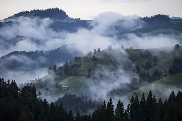 Nebelschwaden ziehen ueber Huegel im Emmental, am Samstag, 26. Juli 2014 vom Schallenberg aus gesehen. (KEYSTONE/Peter Klaunzer)