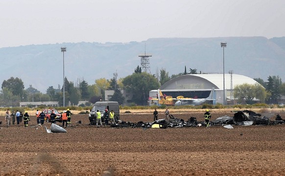 epa06270582 Members from the Emergency Services walk among the fuselage of aSpanish Airf Forces McDonnell Douglas F/A-18 Hornet as it crashed near the Air Base in Torrejon de Ardoz, Madrid, Spain, 17  ...