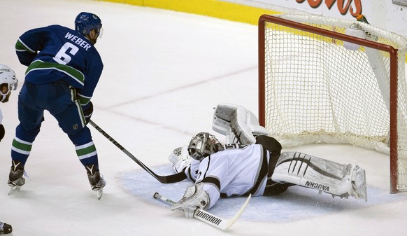 Los Angeles Kings goalie Jonathan Quick (32) stops a shot from Vancouver Canucks defenseman Yannick Weber (6) during the second period of an NHL hockey game in Vancouver, British Columbia, Monday, Apr ...